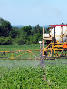 Close up of tractor spraying pesticides on crop